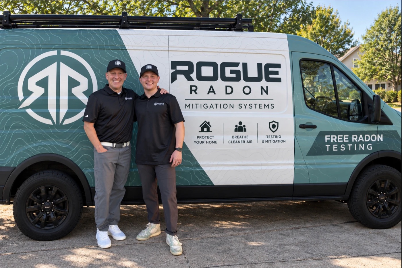 The Rogue Radon father-and-son team standing in front of their branded service van